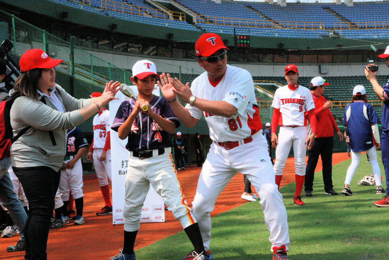 起亞虎職棒球員細心指導台灣小球員。